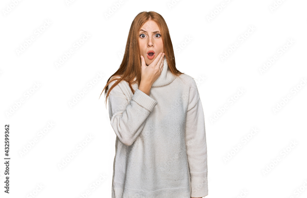 Young irish woman wearing casual winter sweater looking fascinated with disbelief, surprise and amazed expression with hands on chin Young irish woman wearing casual winter sweater looking fascinated with disbelief, surprise and amazed expression with hands on chin