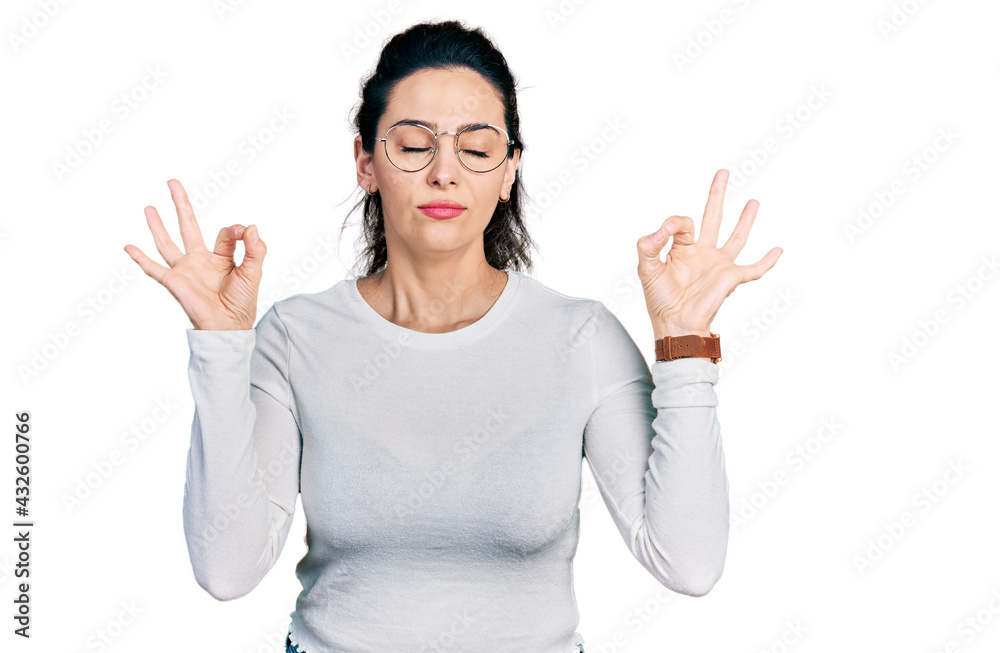 Young hispanic woman wearing casual clothes relax and smiling with eyes closed doing meditation gesture with fingers. yoga concept. Young hispanic woman wearing casual clothes relax and smiling with eyes closed doing meditation gesture with fingers. yoga concept.