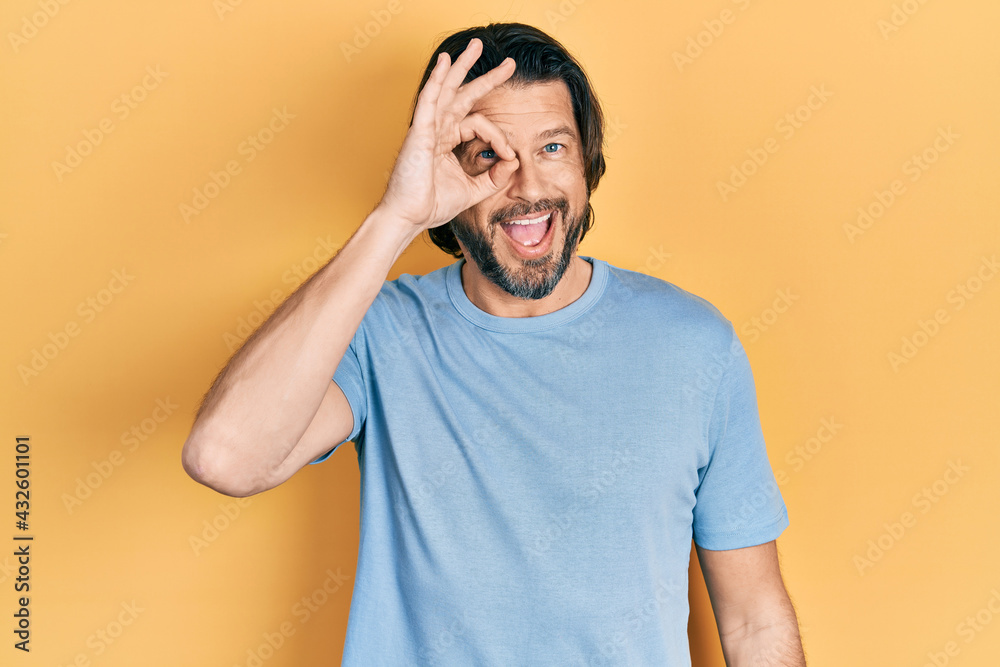 Middle age caucasian man wearing casual clothes doing ok gesture with hand smiling, eye looking through fingers with happy face. Middle age caucasian man wearing casual clothes doing ok gesture with hand smiling, eye looking through fingers with happy face.