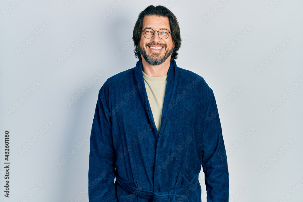 Middle age caucasian man wearing bathrobe and glasses with a happy and cool smile on face. lucky person. Middle age caucasian man wearing bathrobe and glasses with a happy and cool smile on face. lucky person.