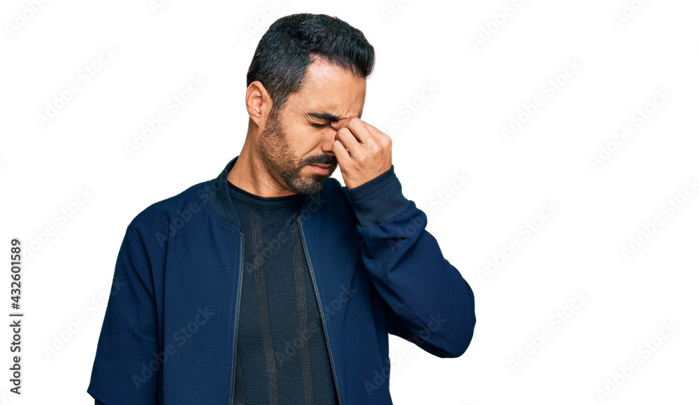 Young hispanic man wearing casual clothes tired rubbing nose and eyes feeling fatigue and headache. stress and frustration concept. Young hispanic man wearing casual clothes tired rubbing nose and eyes feeling fatigue and headache. stress and frustration concept.