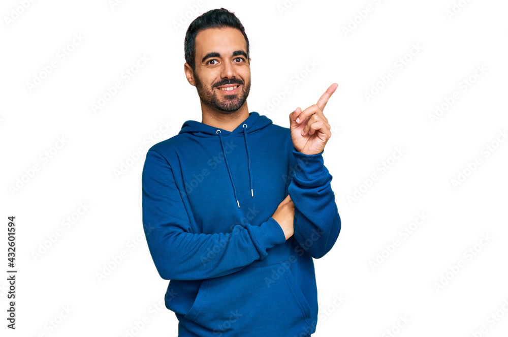 Young hispanic man wearing casual clothes smiling happy pointing with hand and finger to the side Young hispanic man wearing casual clothes smiling happy pointing with hand and finger to the side