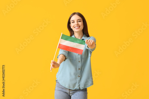 Beautiful young woman with the flag of Republic of Lower Canada on color background