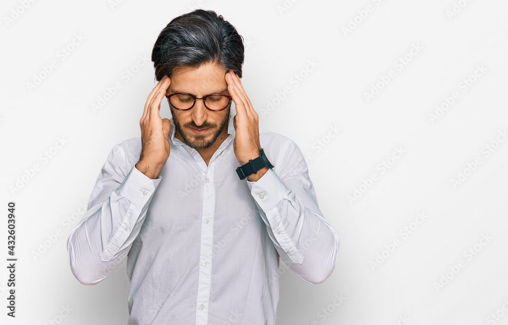 Young hispanic man wearing business shirt and glasses with hand on head for pain in head because stress. suffering migraine. Young hispanic man wearing business shirt and glasses with hand on head for pain in head because stress. suffering migraine.