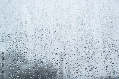 Raindrops on the window, rainy day. Textured wet background, blur at the top of the frame.