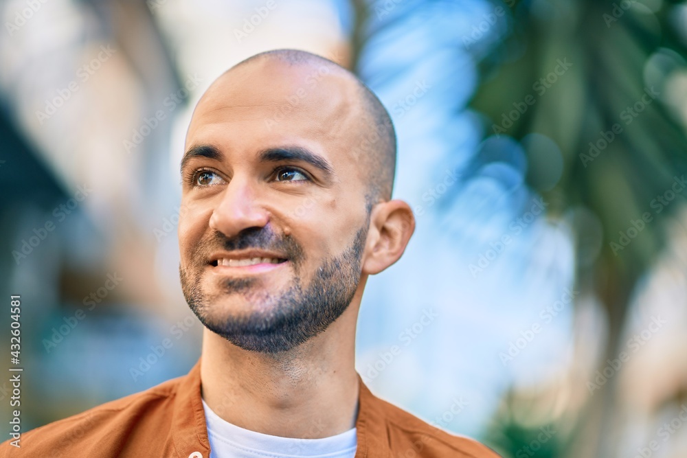 Young hispanic bald man smiling happy standing at the city. Young hispanic bald man smiling happy standing at the city.