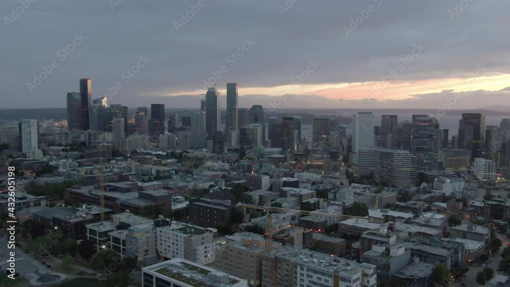 Aerial Shot Of Modern City By Elliot Bay Against Cloudy Sky, Drone Flying Backward Over Cityscape At Sunset - Seattle, Washington Aerial Shot Of Modern City By Elliot Bay Against Cloudy Sky, Drone Flying Backward Over Cityscape At Sunset - Seattle, Washington