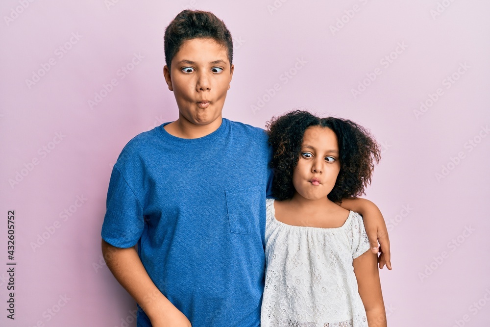 Young hispanic family of brother and sister wearing casual clothes together making fish face with lips, crazy and comical gesture. funny expression. Young hispanic family of brother and sister wearing casual clothes together making fish face with lips, crazy and comical gesture. funny expression.