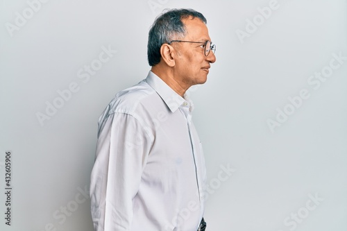 Middle age indian man wearing casual clothes and glasses looking to side, relax profile pose with natural face with confident smile. © Krakenimages.com