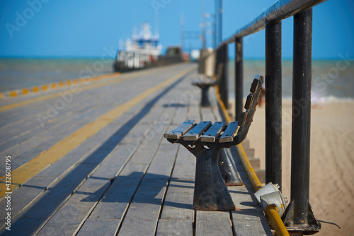 Wooden bench on the marine walkway on a beach in the city of Riohacha. Department of La Guajira Colombia.