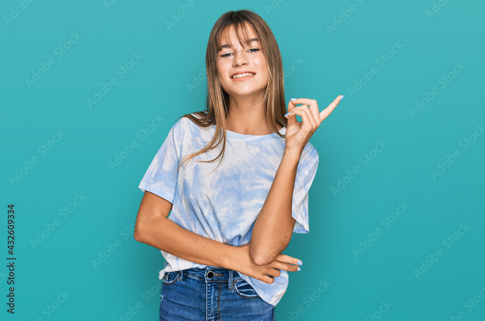 Teenager caucasian girl wearing casual clothes smiling happy pointing with hand and finger to the side Teenager caucasian girl wearing casual clothes smiling happy pointing with hand and finger to the side