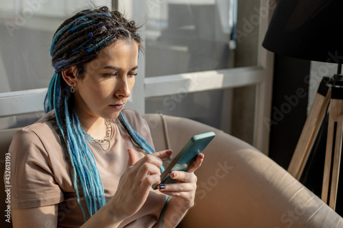 Confident hipster woman chatting surfing internet use smartphone typing message mobile application
