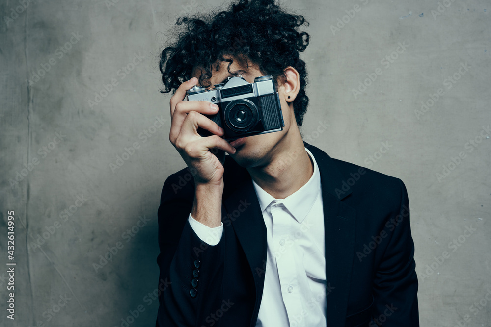 photographer with a camera in a classic suit curly hair Studio Model photographer with a camera in a classic suit curly hair Studio Model