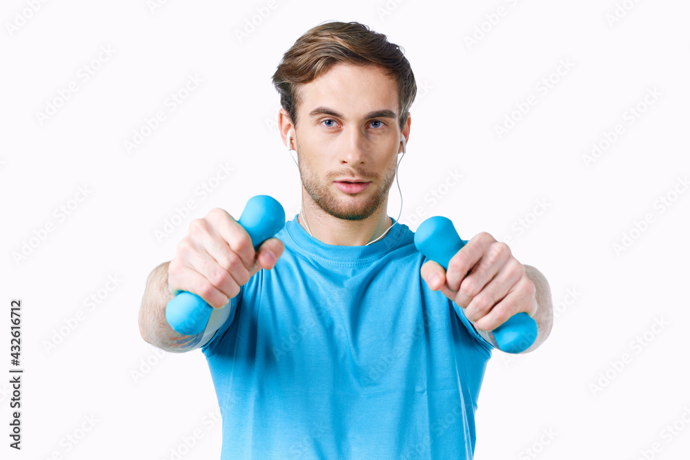 man in blue t-shirt from dumbbells in hands fitness