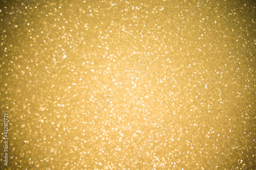 Gold glitters background. shimmering blur spot lights Bokeh Shiny gold light background.