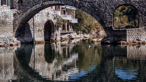 Montenegro - The ancient arched stone bridge in the old town of Rijeka Crnojevića spanning the river of a same name © DeStefano