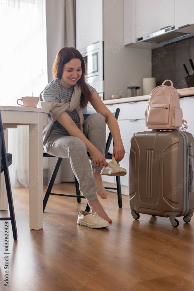 Modern suitcase full of things, handbag and straw hat. Baggage case packing getting ready to travel Modern suitcase full of things, handbag and straw hat. Baggage case packing getting ready to travel