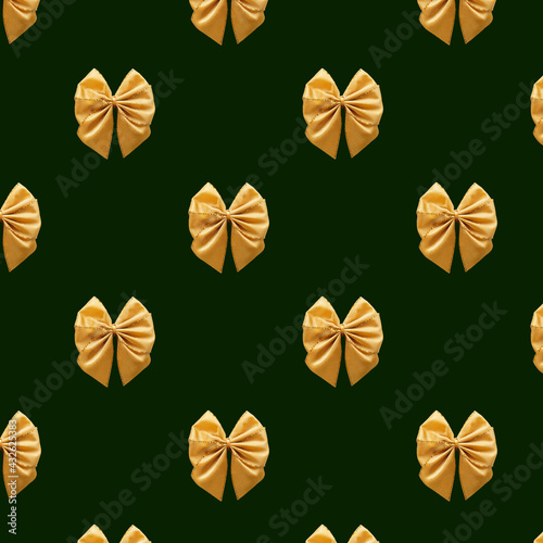 Seamless pattern Gift Satin golden Bow isolated on green background. Pattern for fabric print  wrapping paper design. Birthday  New Year and Christmas background. Holiday design