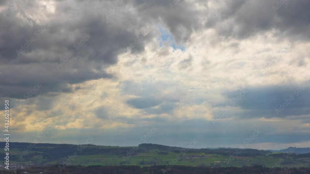 Timelapse rays of light shining through the clouds. Clouds with sunbeams over the hills. Timelapse rays of light shining through the clouds. Clouds with sunbeams over the hills.