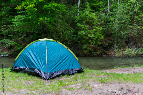 Tent on the water's edge. Camping in the mountains.