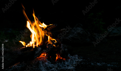 Campfire in nature at night. Dark background. Spending time in nature.