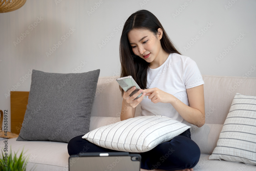 Asian girl are looking at mobile phones to follow up and read social Asian girl are looking at mobile phones to follow up and read social