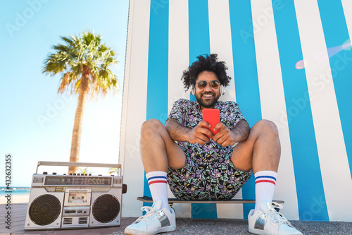African american man listening music with vintage boombox stereo outdoor with beach in background - Summer lifestyle, travel and party concept - Focus on face