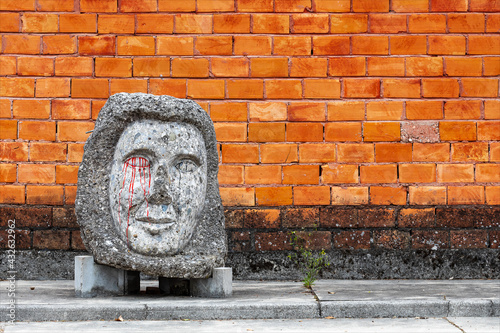 Artefatto, manufatto in cemento lungo la via della città con sfondo un muro di mattoni. photo