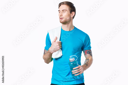handsome man with a bottle of water in his hands sport fitness tattoo