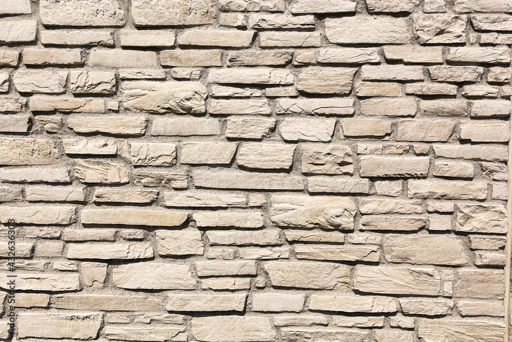 Off white brick stone wall, different size bricks, textured Off white brick stone wall, different size bricks, textured