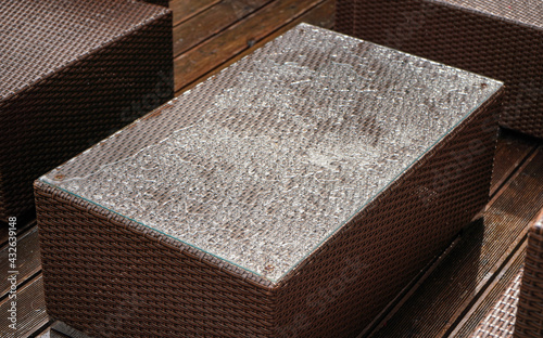 Simple brown artificial rattan garden furniture, top covered with raindrops, closeup detail