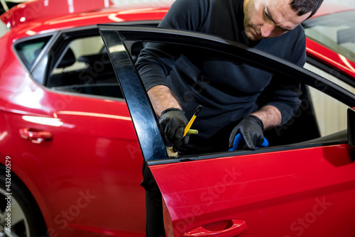 Car service worker cleans interiror with special brush