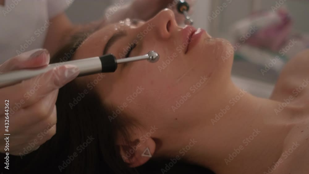 Face skin care procedures by a beautician. Microcurrent therapy of the face of a young beautiful girl. Face skin care procedures by a beautician. Microcurrent therapy of the face of a young beautiful girl.