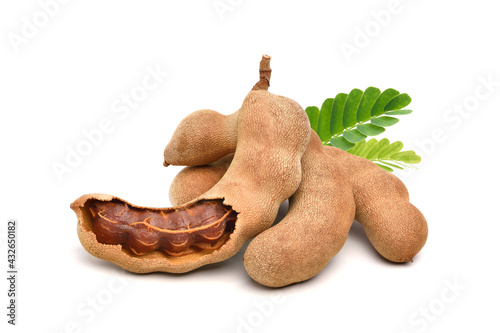 Pile of tamarind fruits with green leaves isolated on white background. photo