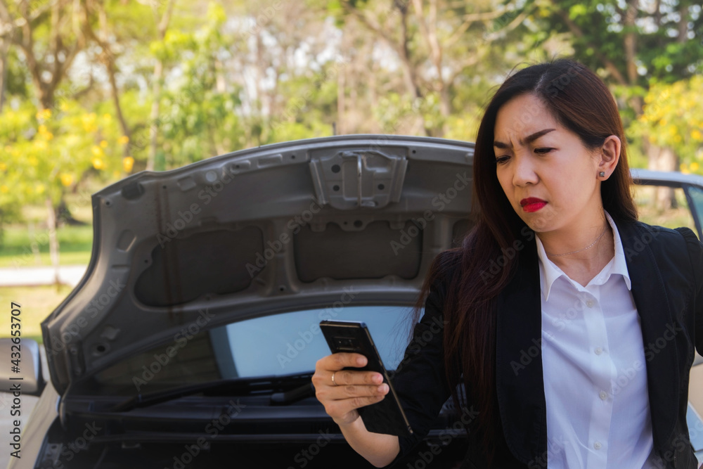 Car insurance concept : Female businessmen are angry with the use of the phone, unable to contact anyone because the signal is missing while needing help because the car is off during the trip.

