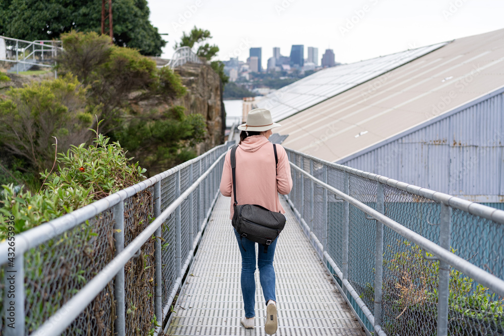 view of lady from behind walking on the bridge