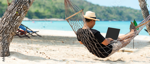 Принти на полотні Lifestyle freelance man using laptop working and relax on the beach