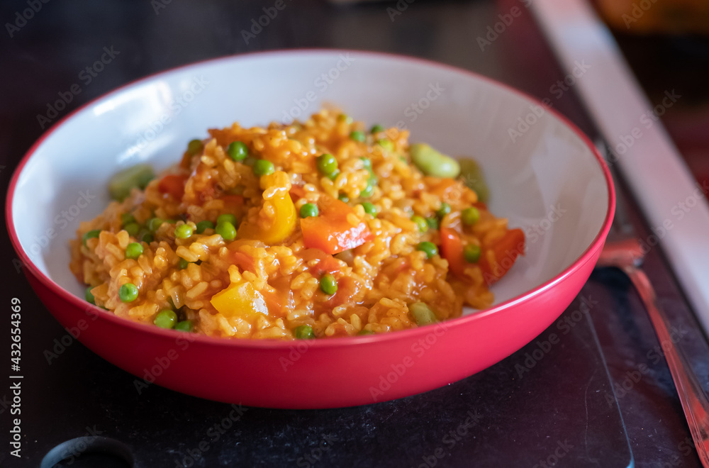Close up of a healthy, nutritious and homemade vegetable paella in a red dinner bowl with selective focus, shallow depth of field and bokeh Close up of a healthy, nutritious and homemade vegetable paella in a red dinner bowl with selective focus, shallow depth of field and bokeh