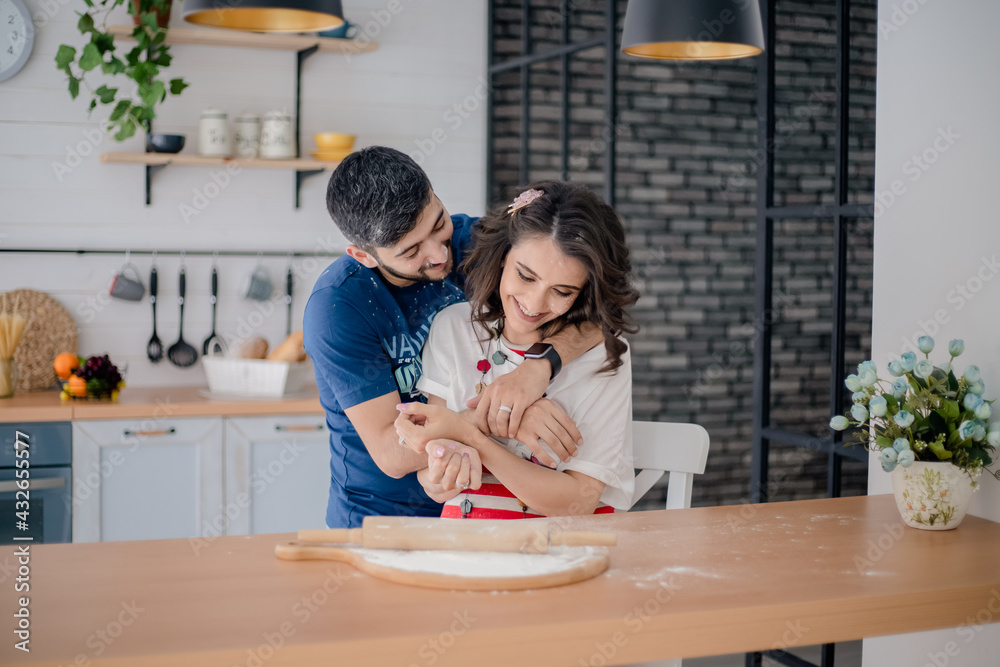 Happy couple. Husband and pregnant wife sit hugging in the kitchen Happy couple. Husband and pregnant wife sit hugging in the kitchen