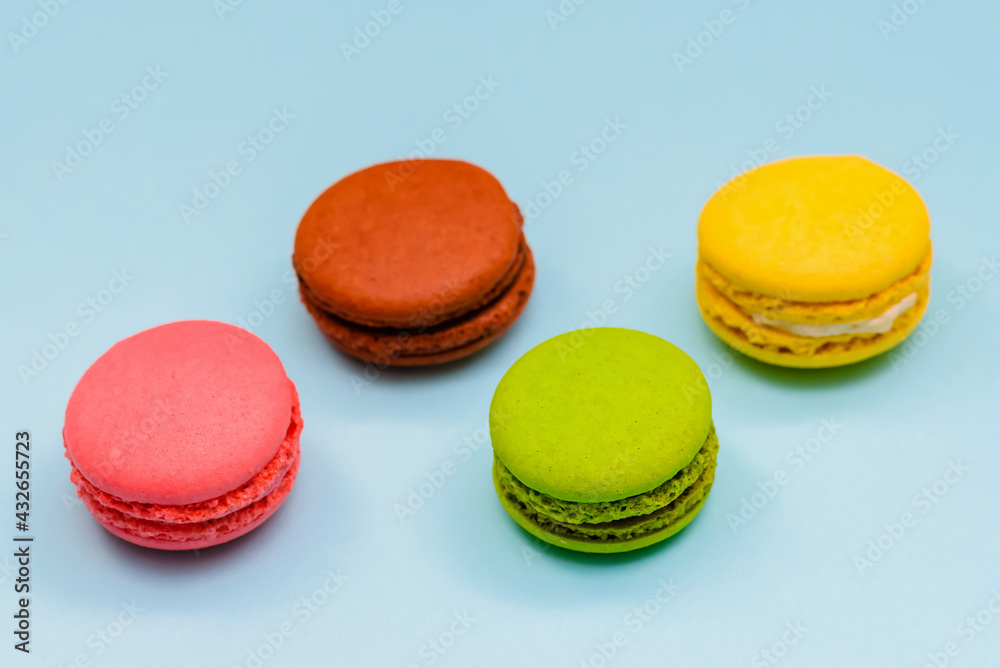 multicolored macaron cakes on a blue paper background multicolored macaron cakes on a blue paper background