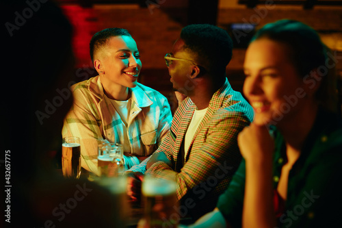 Happy African American couple talking during a night date at the bar.