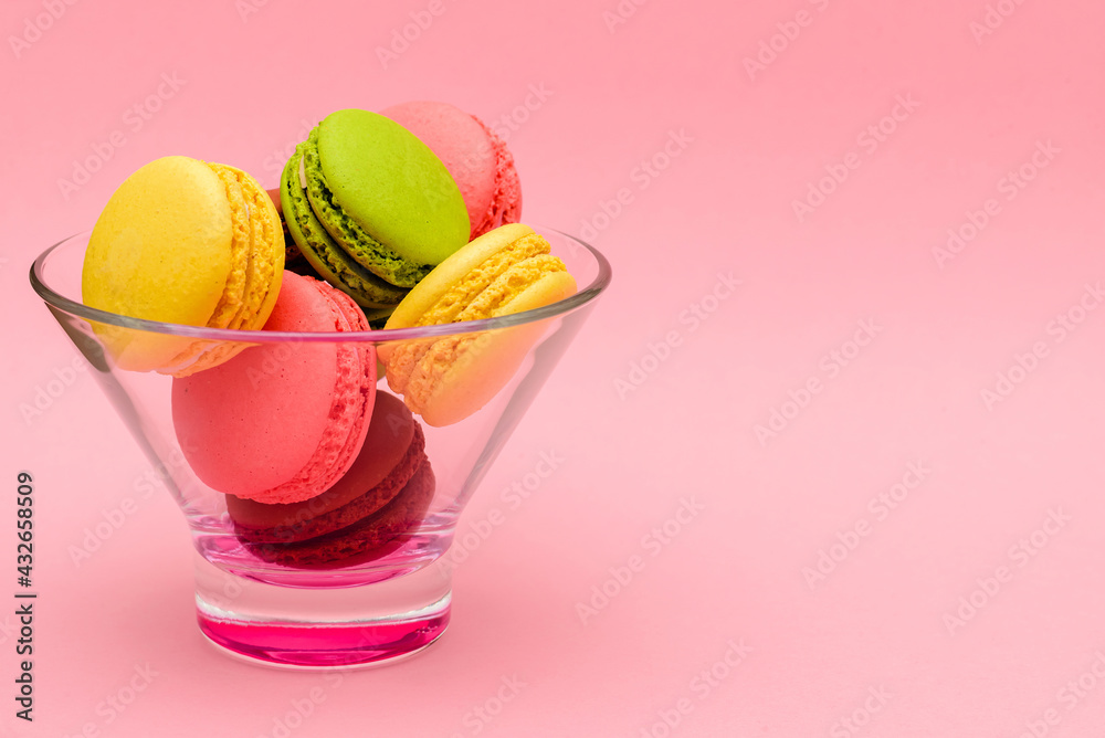 several color macaron cakes in a glass vase on a pink background several color macaron cakes in a glass vase on a pink background