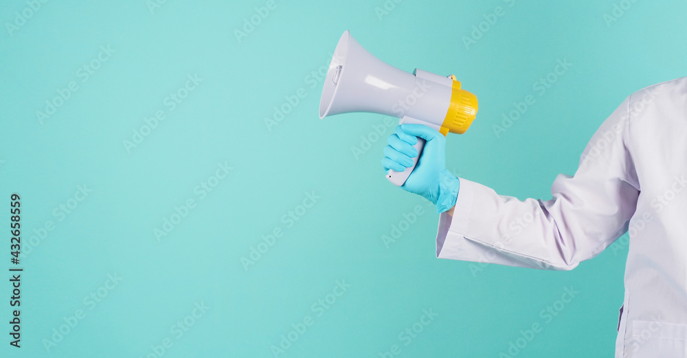 Megaphone in hand.Man wear doctor gown and blue medical glove on mint green or Tiffany Blue background. Studio shooting. Megaphone in hand.Man wear doctor gown and blue medical glove on mint green or Tiffany Blue background. Studio shooting.