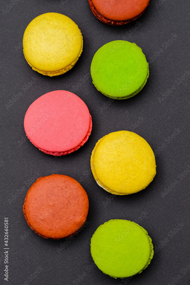 different multicolored macaron cakes on a black background different multicolored macaron cakes on a black background