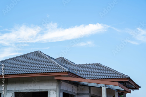 New tile roof of home with spanish tiled roof at unfinished house construction, Roof structure © tong2530
