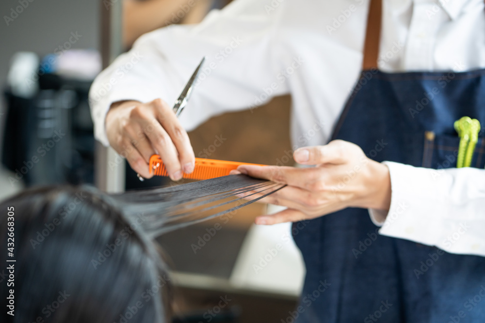Close up shot at hand of Hair stylish while do hair cut and hair