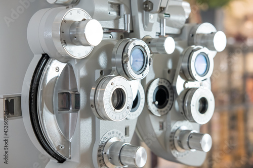 Selective focus at Optometry frame equipment. With blurred background while optometrist examine eye visual system of elder patient women with professional machine before made glasses.