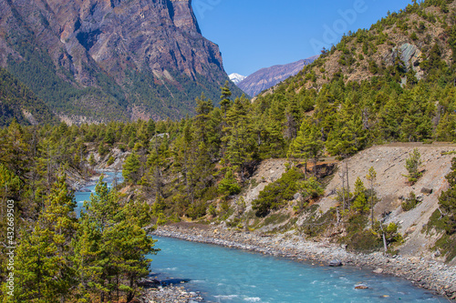 Beautiful landscape with high Himalayan mountains, curving river, green forest and blue sky in autumn in Nepal