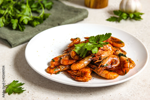 Grilled shrimps with garlic, parsley and black pepper on the white background
