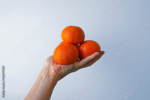 Tangerines on hand in a bright background